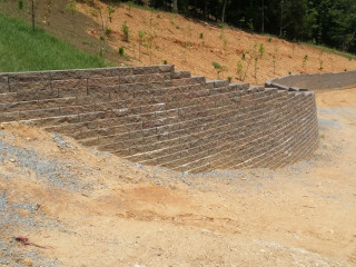 Retaining Wall Installed To Stabilize Hillside Above Driveway